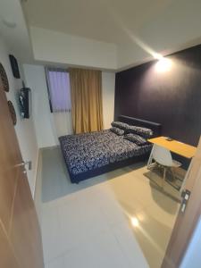 niewielka sypialnia z łóżkiem i stołem w obiekcie Homey 1 Bed Room Apartement Margonda Evenciio Depok w mieście Pondoktjina 1