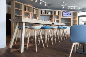 a kitchen with a wooden bar with stools at ibis Chur in Chur