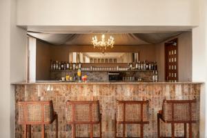 a bar with four chairs and a counter at Manuscript - Jhilwara Haveli in Udaipur