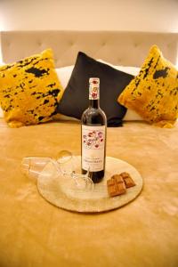 een fles wijn en glazen op een bed bij Suites Rania in Áyios Yeóryios