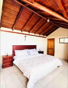 a bedroom with a large bed with a wooden ceiling at Casa de campo acogedora con WIFI- ZONA BBQ- PARQUEO in Loja