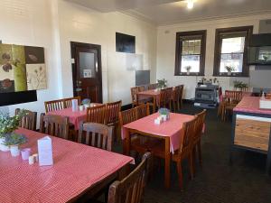 comedor con mesas rojas y sillas de madera en The Exchange Hotel Blayney, en Blayney