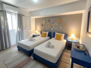 een hotelkamer met 2 bedden en 2 tafels bij Summer Dream Cottage, 2BR, Beautiful sea view in Mochlos