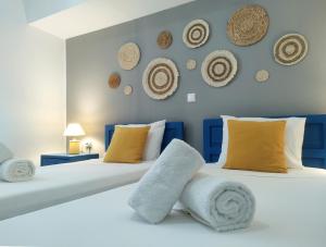 twee bedden in een slaapkamer met hoeden aan de muur bij Summer Dream Cottage, 2BR, Beautiful sea view in Mochlos