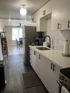 a kitchen with white cabinets and a sink and a table at Town Inn in Prescott