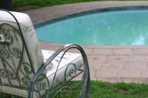 a metal bench next to a swimming pool at Grootgeluk in Naboomspruit