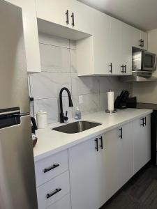 eine weiße Küche mit einer Spüle und einem Kühlschrank in der Unterkunft Town Inn in Prescott