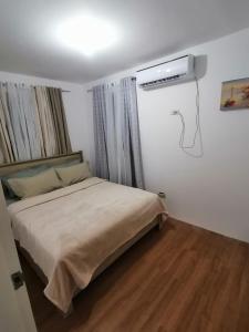 um quarto com uma cama e ar condicionado na parede em Ones stop shop Transient House em Butuan