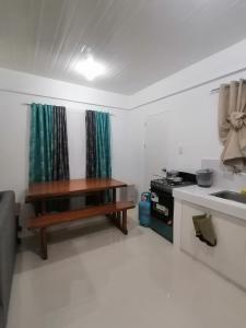 uma cozinha com um lavatório e uma mesa num quarto em Ones stop shop Transient House em Butuan