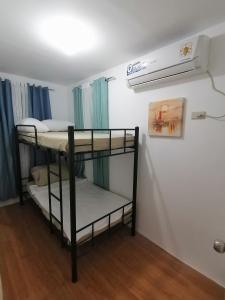 a bedroom with two bunk beds in a room at Ones stop shop Transient House in Butuan