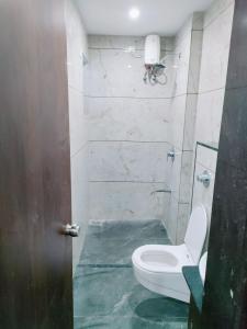 a bathroom with a white toilet in a room at Hotel Nandnandan in Dwarka