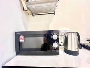 - un four micro-ondes assis sur un comptoir avec une cafetière dans l'établissement G8 1-8Pax Sunway Medical Center Geo avenue Sunmed, à Kampong Penaga
