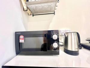 a microwave sitting on a counter with a coffee pot at G8 1-8Pax Sunway Medical Center Geo avenue Sunmed in Kampong Penaga