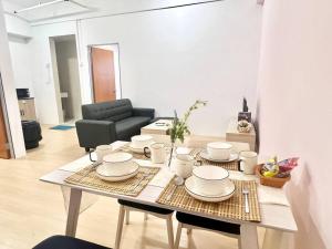 a table with plates and cups on it in a living room at G8 1-8Pax Sunway Medical Center Geo avenue Sunmed in Kampong Penaga