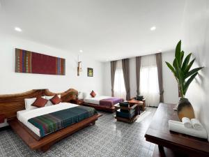 Habitación de hotel con 2 camas y sala de estar. en Villa Romduol, en Kampot