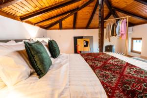 a bedroom with a large white bed with green pillows at Slona, Heritage Home in Old Town Plovdiv in Plovdiv
