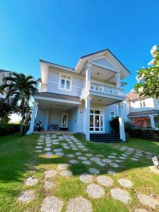 ein großes weißes Haus mit einem Rasenhof in der Unterkunft 3 Bedroom Villa Sealink Mui Ne managed by Vipol in Ấp Phú Tịnh (2)