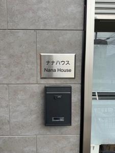 東京にあるNANA HOUSEの建物脇の納屋看板