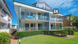 an apartment building with a balcony and a yard at Blue Pacific 2 in Yamba