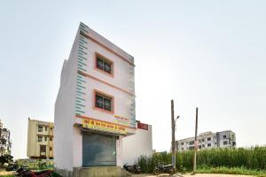 ein weißes Gebäude mit einer großen Tür an der Seite in der Unterkunft SPOT ON Devlok Guest House in Patna