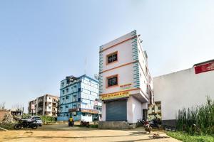 ein hohes weißes Gebäude mit einer Garage in einer Stadt in der Unterkunft SPOT ON Devlok Guest House in Patna