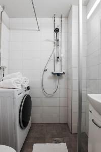 łazienka z prysznicem i pralką w obiekcie Elegantti yksiö keskustassa w mieście Lahti