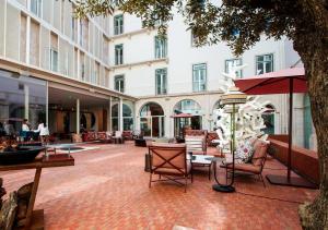 un cortile con sedie e tavoli e un edificio di Convent Square Lisbon, Vignette Collection by IHG a Lisbona