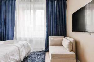 um quarto com uma cama, uma cadeira e uma televisão em Elegantti yksiö keskustassa em Lahti