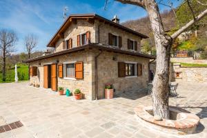 a stone house with a tree in front of it at Fanano - Panoramic Villa by Alterego in Fanano