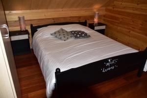 ein Schlafzimmer mit einem schwarz-weißen Bett und zwei Kerzen in der Unterkunft Bouleau in Vresse-sur-Semois