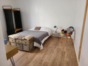 a bedroom with a bed and a wooden floor at MARCELINE in Lannion