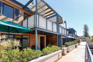 Casa con balcón con sombrilla y plantas en Suffolk Villa Fremantle On Your Doorstep, en Fremantle