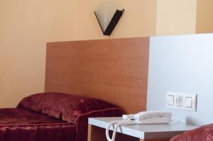 um quarto com um telefone na parede ao lado de um sofá em Hotel Rausan em Alfajarín