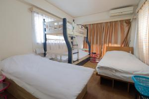 東京的住宿－AKARENGA house，一间卧室配有两张床和一张双层床。
