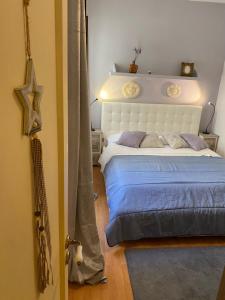 タオルミーナにあるCasa Cajoのベッドルーム(青いシーツを使用した大きな白いベッド付)