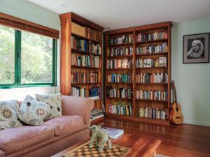 a living room with a couch and book shelves filled with books at House of Pania BnB in Napier
