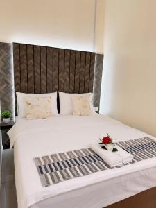 a bedroom with a large white bed with flowers on it at Fiqthya Chalet & Cafe in Tioman Island