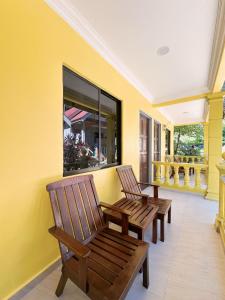 two wooden chairs sitting on a porch with a window at Fiqthya Chalet & Cafe in Tioman Island