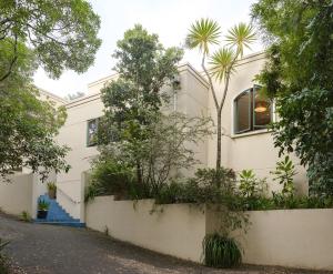 une maison blanche avec des escaliers bleus et des arbres dans l'établissement House of Pania BnB, à Napier