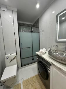 un bagno con lavatrice e lavandino di Жк Керуен Сарай 2 a Türkistan