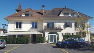 a blue car parked in front of a house at Auberge de Founex in Founex