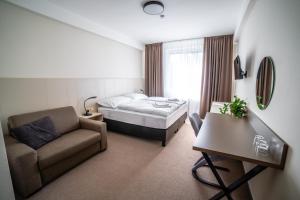 a hotel room with a bed and a chair at Hotelový Dům in Olomouc