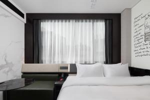 a hotel room with two beds and a window at Shenzhen Futian Xiameilin Metro Station CitiGO Hotel in Shenzhen