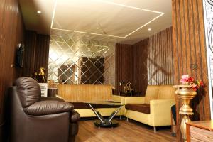 a salon with a couch and a table and chairs at Hotel Padma Krishna in Pune