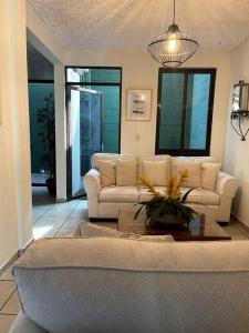 uma sala de estar com um sofá e uma mesa em Casa en Residencial Privado Lomas de San Francisco em San Salvador
