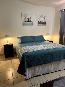 1 dormitorio con 1 cama con sábanas azules y 2 lámparas en Casa en Residencial Privado Lomas de San Francisco en San Salvador