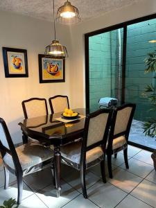 uma sala de jantar com uma mesa preta e cadeiras em Casa en Residencial Privado Lomas de San Francisco em San Salvador