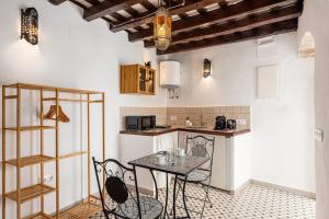 uma cozinha com mesa e cadeiras num quarto em Casa Lunarito em Vejer de la Frontera