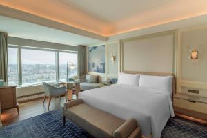 哈爾濱的住宿－哈尔滨富力丽思卡尔顿酒店，卧室配有一张白色大床和一张书桌