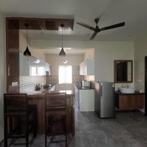 a kitchen with a ceiling fan and a refrigerator at Sukrithi Premium Serviced Apartment - F2 in Chennai